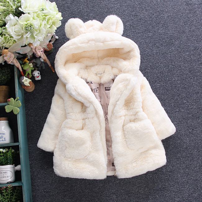 White fur-lined hooded coat on a dark background with decorative elements.