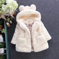 White fur-lined hooded coat on a dark background with decorative elements.