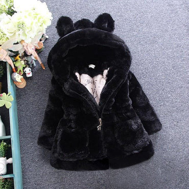 Black fur coat with pom-pom hood on a gray background